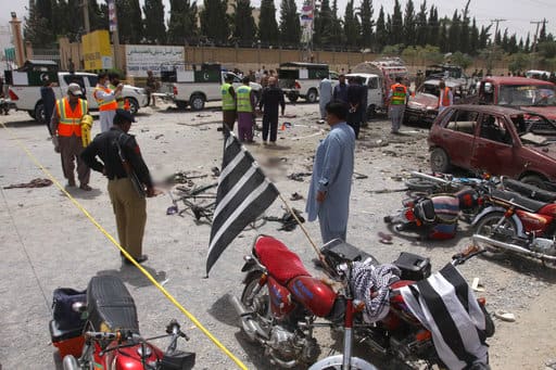 Pakistani volunteers and security officers visit the site of a bombing in Quetta, Pakistan, Wednesday, July 25, 2018. (AP Photo/Arshad Butt)