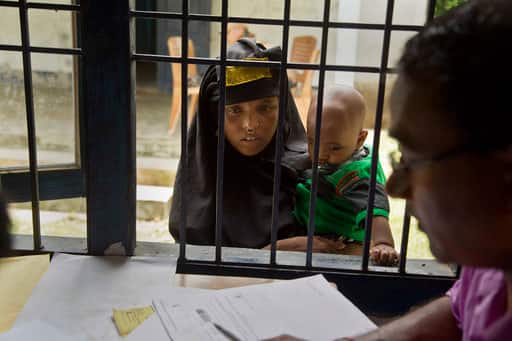 A woman holding her child checks if their names are included in the National Register of Citizens at a draft center in Mayoung, about 55 kilometers (34 miles) east of Gauhati, India, Monday, July 30, 2018. PIC/AP.