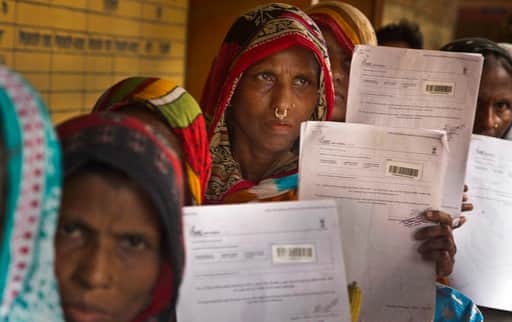 Women stand in a queue to check if their names are included in the National Register of Citizens at a draft center in Bur Gaon village, 70 kilometers (44 miles) east of Gauhati, India, Monday, July 30, 2018. India on Monday released a final draft of a list of its citizens in the northeastern state of Assam, leaving some 4 million people on edge to prove their Indian nationality. (AP Photo/Anupam Nath)