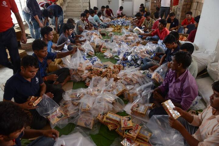 Indian labourers prepare food aid from Punjab state government to be shipped to flood-hit Kerala, in Jalandhar AFP PHOTO 