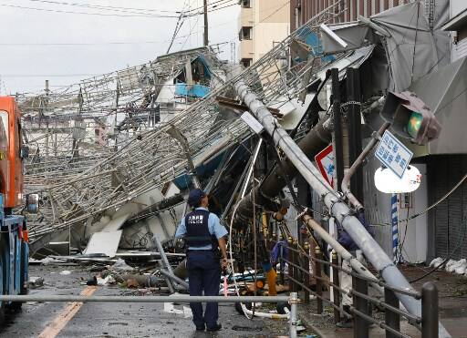 Damaged traffic boards and telecommunication relay poles are seen after they were brought down by strong winds/ IMAGE: AFP PHOTO / JIJI PRESS