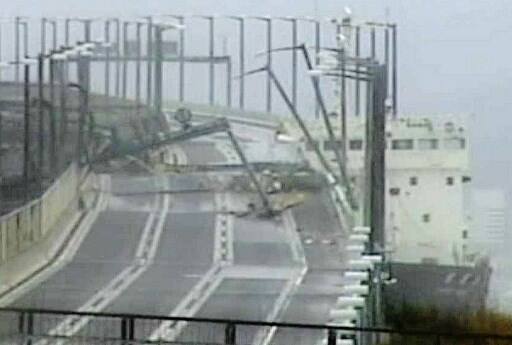 A tanker ship (R) tha had smashed into a bridge connecting the city of Izumisano with Kansai international airport, with the top part of the ship knocking away a part of the bridge, as Typhoon Jebi made landfall around midday in southwestern Japan./ IMAGE: AFP PHOTO / JIJI PRESS AND Western Nippon Expressway