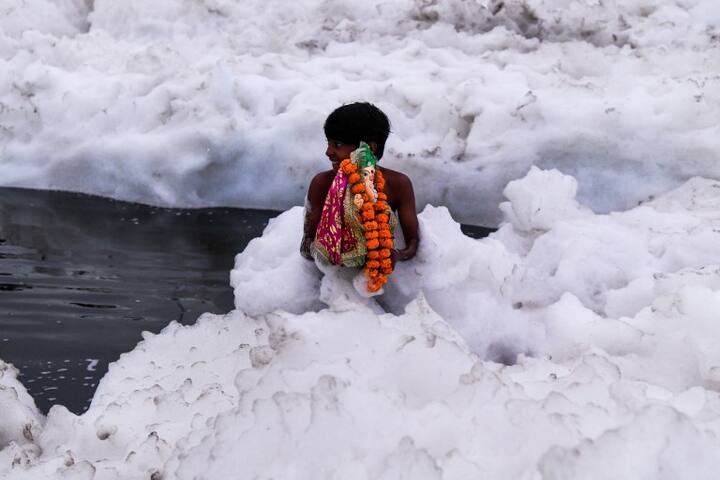 A young boy immerses idol of Hindu god Lord Ganesh in the polluted Yamuna river on the ninth day of the eleven-day long festival Ganesh Chaturthi in New Delhi on September 21, 2018. (AFP)