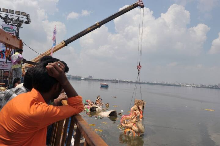Devotees watch as crane workers immerse an idol of Hindu deity Ganesh in the Hussain Sagar Lake on the eleventh day of the Ganesh Chaturthi festival in Hyderabad on September 23, 2018. (AFP)