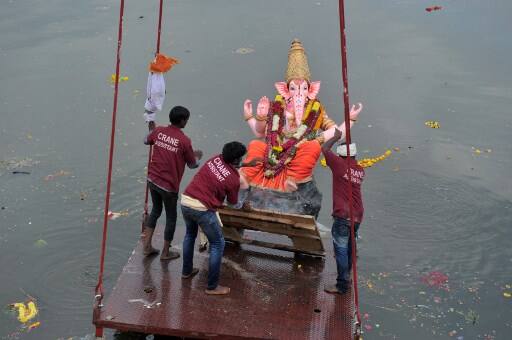 Crane workers immerse an idol of the Hindu deity Ganesh in the Hussain Sagar Lake on the eleventh day of the Ganesh Chaturthi festival in Hyderabad on September 23, 2018.(AFP)