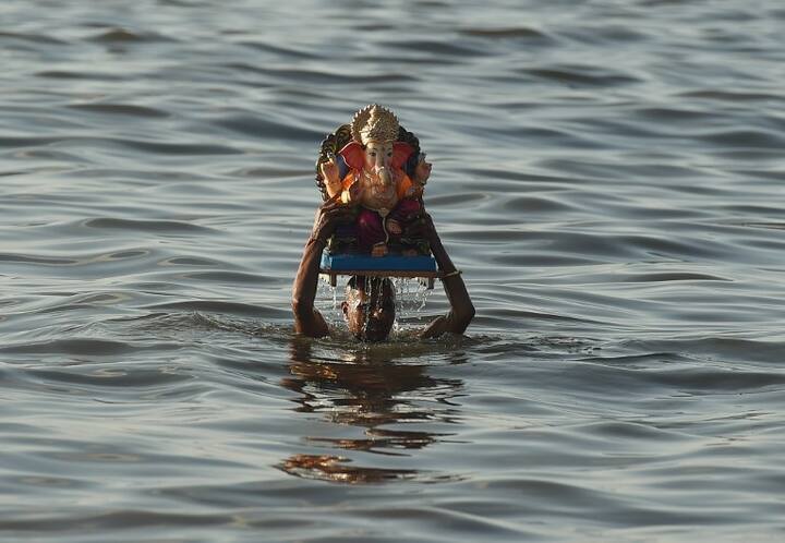 An Indian Hindu devotee carries an idol of the elephant-headed Hindu deity Ganesh for immersion at Dadar Chowpatty beach on the fifth day of the eleven-day long festival Ganesh Chaturthi in Mumbai on September 17, 2018. (AFP)