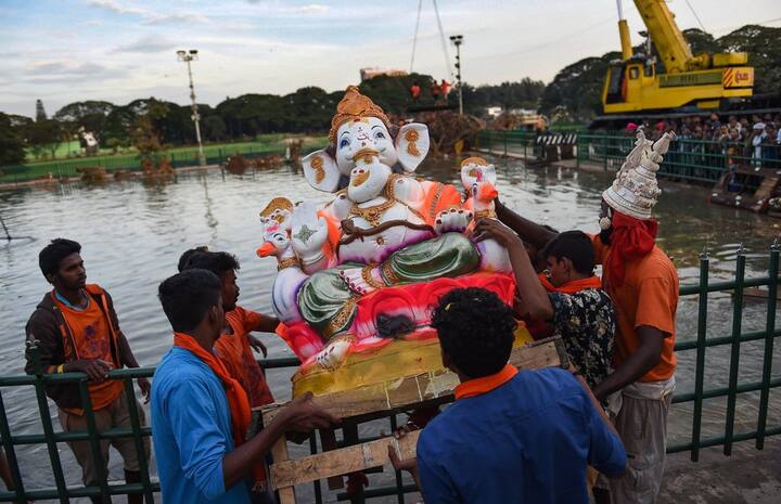 Devotees carry the Idol of Lord Ganesha for the immersion in a makeshift pond in Ulsoor lake during the 5th day of Ganesh Chaturthi festival in Bengaluru on Monday. (PTI)