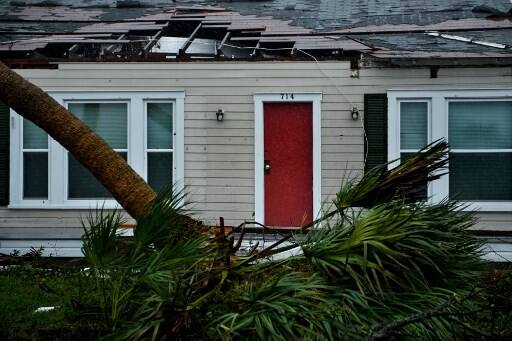 A house is seen with damage to its roof and downed trees during Hurricane Michael October 10, 2018 in Panama City, Florida. - (Photo by Brendan Smialowski / AFP)