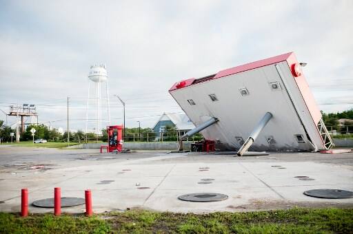 The overhang of a gas station is toppled over in the aftermath of Hurricane Michael on October 11, 2018 in Inlet Beach, Florida.. (Photo by Emily KASK / AFP)