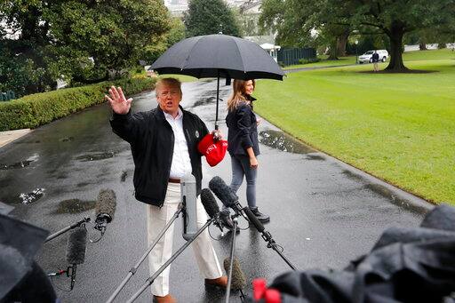 Melania patiently waited on a side for Trump to finish up his comments. Trump however seemed totally unaware of the fact that his wife was getting wet in the rain. (AP Photo/Pablo Martinez Monsivais)