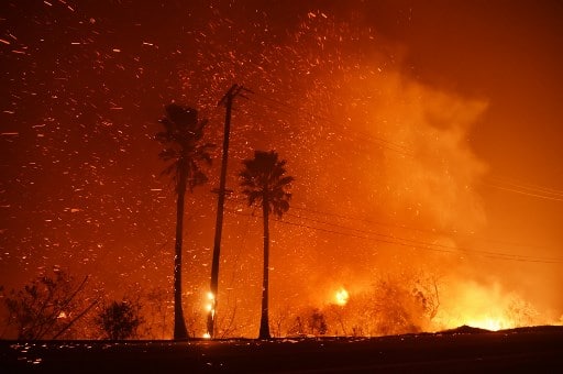 A power line catches fire as the Woolsey fire burns on both sides of Pacific Coast Highway (Highway 1) in Malibu, California. (Photo by Robyn Beck / AFP)