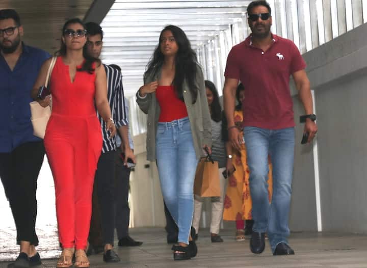 Kajol wearing a red jump suit looked stylish while daughter and husband chose to go casual with Nysa wearing an olive green jacket over a fitted red top with denims and Ajay wore a dark magenta tee with denims.