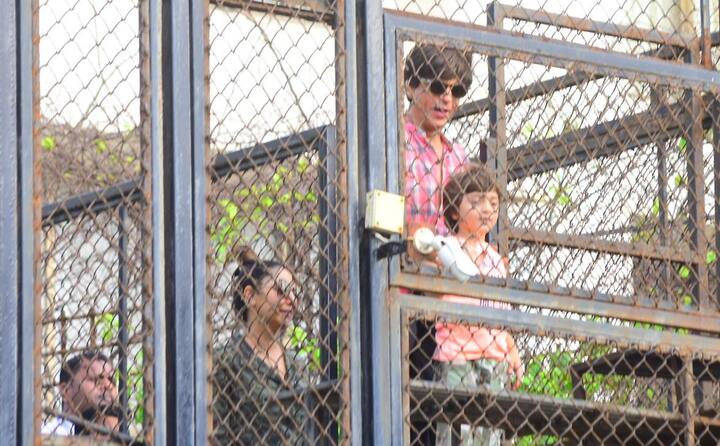 Srk with his 5 yr old son Abrahm looking cute in a pink tee and grey pants, and with wife Gauri standing behind, shows up for the fans at Mannat balcony.