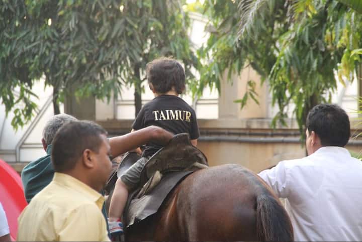 The cutie pie can be seen wearing a black t-shirt and beige shorts. The t-shirt had the initials of his name-Taimur on it.