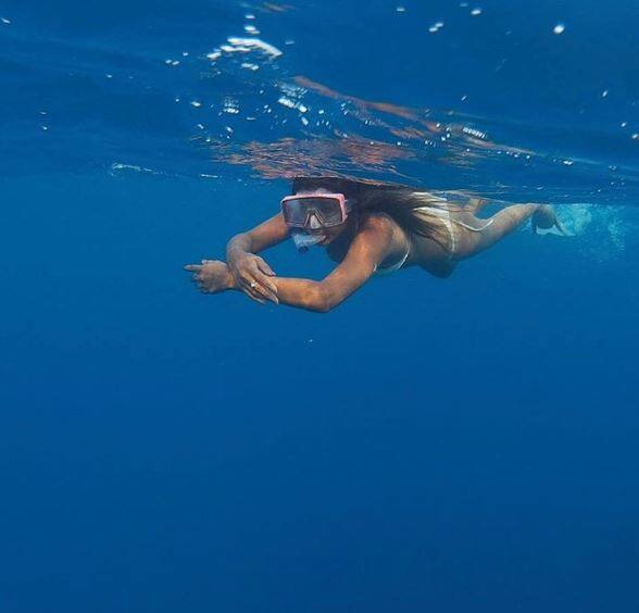 Sporting a two-piece white bikini Nia can be seen diving off and snorkeling