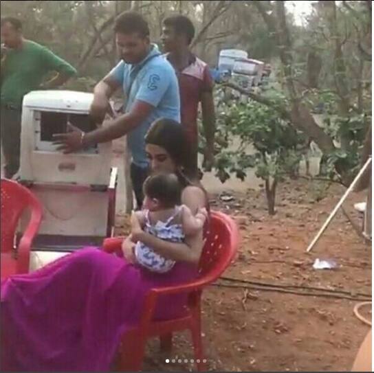 Look at Mouni sitting with one twin girl looking after her and getting the fan to keep her cool in this heat