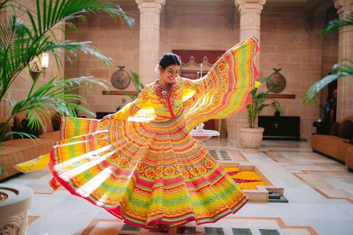 The bride Priyanka Chopra dancing in a yellow lehenga during her mehendi ceremony.