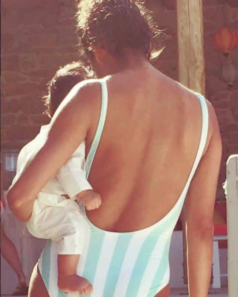 The actress shared this adorable pic holding her newborn baby Zack wearing a striped blue and white swimsuit.