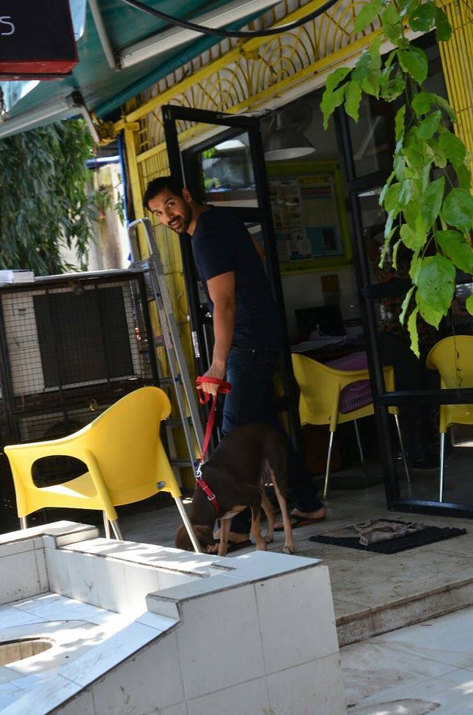 Looking handsome in a blue tshirt and denims, John finally shows up with his dog 'Bailey' holding her by red leash.