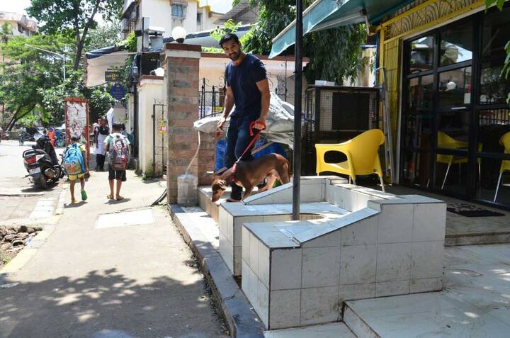 John walks with the brown colored Bailey to his car as the cameras clicked him