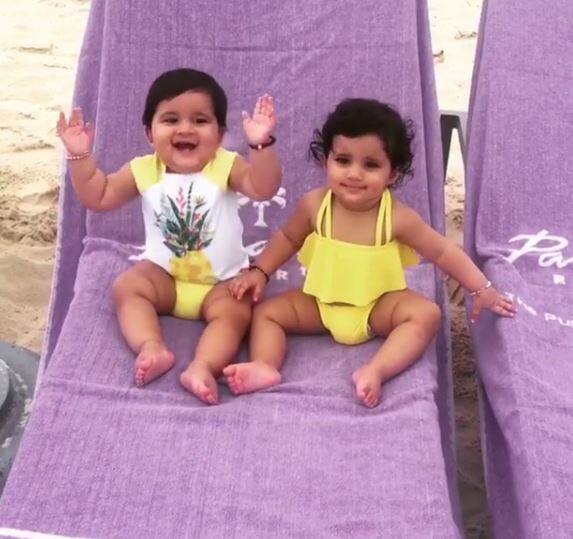 Wearing a matching yellow baby swim suit the cuties can be seen enjoying as their parents cheer them up!