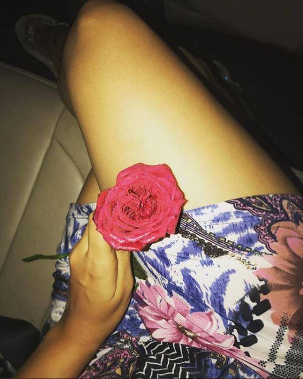 Holding a red rose while sitting in the car wearing a short skirt she writes -