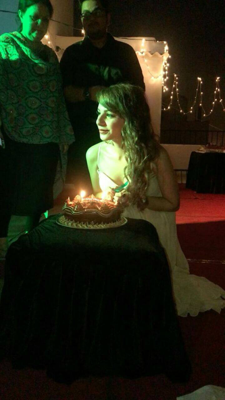 The birthday girl all set to cut her cake, her mom can be seen in the backdrop!