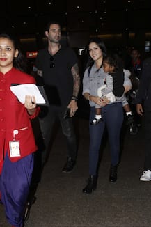 Sunny Leone spotted at Airport with hubby Daniel & protects daughter Nisha from camera flashes!