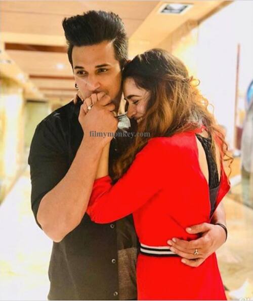 Yuvika glowing in a red dress and Prince in a shirt with tee inside strike another pose after exchanging their engagement rings and Yuvika shares this one with the message -