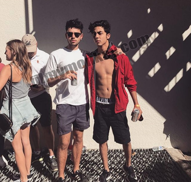 This is the picture that's just begun to make rounds on the internet from Aryan-Harry's Vietnam trip as we can see the jr SRK flaunting his famous 6 pack abs underneath the unbuttoned shirt, holding beer in his hand and flashing his Calvin Klein underwear strap. Aryan poses here with Harry. We've seen Bolywood hunks like Varun Dhawan with the peeking underwear elastic and guess the future star is shedding all apprehensions now too.