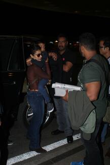 IN PICS: Actress Kajol carries a sleepy son Yug at the airport along with hubby Ajay and daughter Nysa as the Devgns leave for a family vacation!