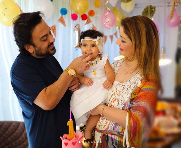 Baby Medina looked cute as a button in a white dress while cutting a three-tier birthday cake wrapped in her mommy's arms