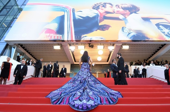 The Dubai-based designer revealed the details for this dress: it's completely covered in Swarovski crystals and French palettes; it consists of ultra-violet, midnight blue, and red thread works; and it boasts a 20-foot train that mimics