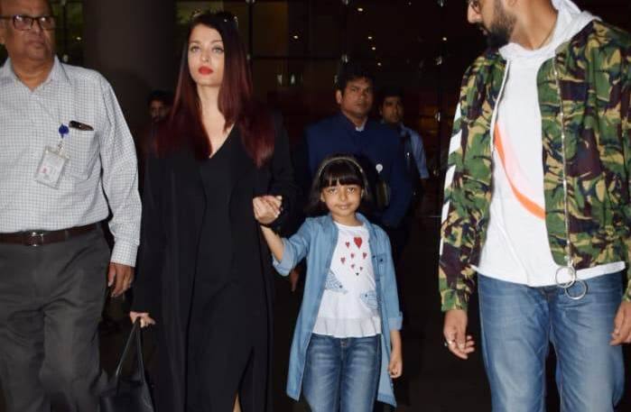 While Aishwarya looked stunning in a black dress, Abhishek wore a white tee with denims and a camouflage jacket on top. Their daughter who looked please with cameras presence around, wore a denim shirt over a sweet white top with denim jeans.