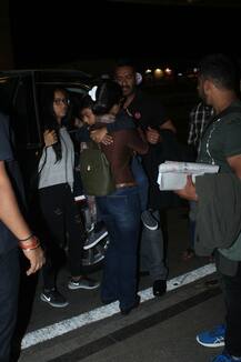 IN PICS: Actress Kajol carries a sleepy son Yug at the airport along with hubby Ajay and daughter Nysa as the Devgns leave for a family vacation!