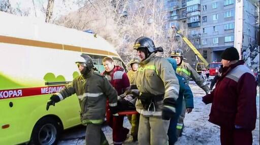 This handout picture released by The Russian Emergency Situations Ministry on January 1, 2019, shows emergency officers transporting a survivor/ (Photo by HO / RUSSIAN EMERGENCY SITUATIONS MINISTRY / AFP) 