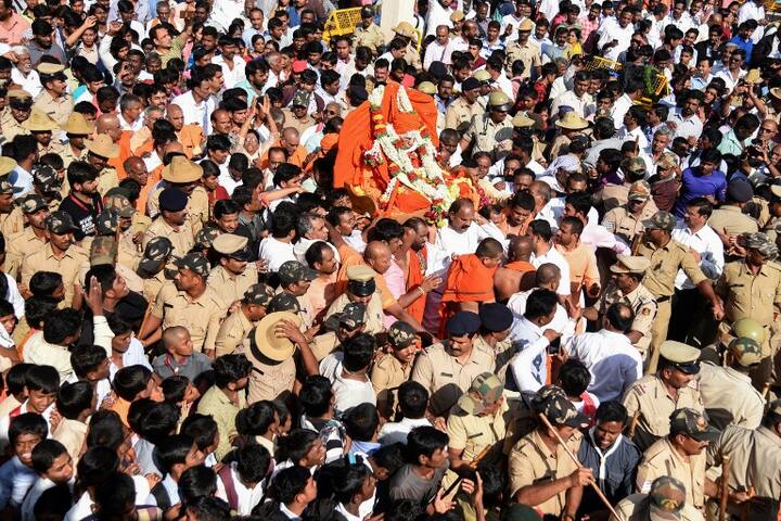 Graphic content / Crowds gather around the body of Indian spiritual leader Shivakumara Swami after his death at the age of 111 in Tumakuru, some 75km northwest of Bangalore, on January 21, 2019. - The spiritual leader who was head of the Lingayatism faith, a major tradition within Hinduisum, was known for his philanthropic activities. (Photo by STR / AFP)