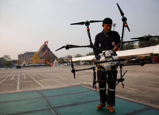 The city's governor invited critics to brainstorm better ideas to improve the air quality in the Thai capital. In the picture, drone pilots prepare to launch a water-spraying drone before flying over the Suthat Temple in Bangkok on Thursday. (AP Photo/Sakchai Lalit)