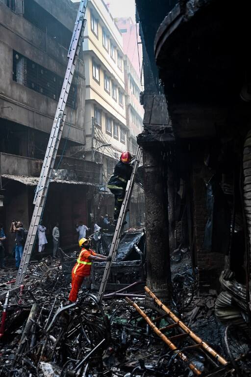 A firefighter climbs a ladder for an inspection in the aftermath of a fire that broke out in Dhaka. (AFP)