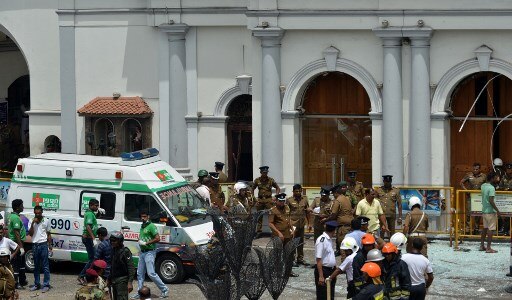 An ambulance is seen outside the church premises with gathered security personnel following a blast at the St. Anthony's Shrine in Kochchikade, Colombo on April 21, 2019. No one has claimed the responsibly of the attack so far. It is yet to ascertained whether or not this was a terror attack. (Photo by ISHARA S. KODIKARA / AFP)