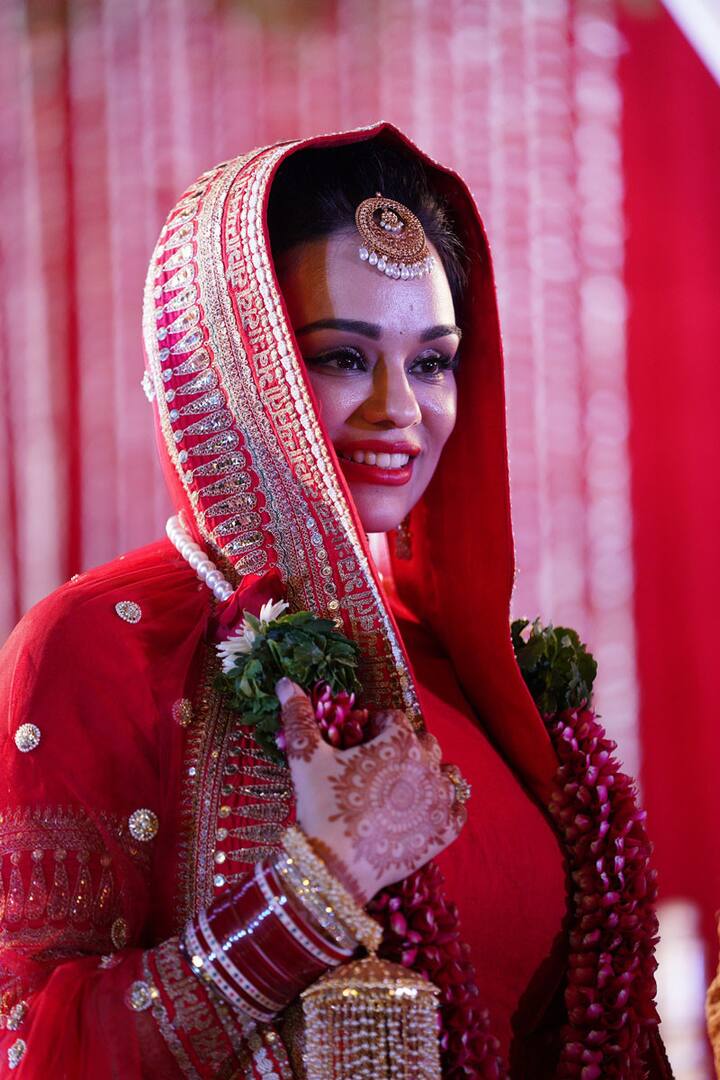 The bride was looking like a million bucks in her red attire 