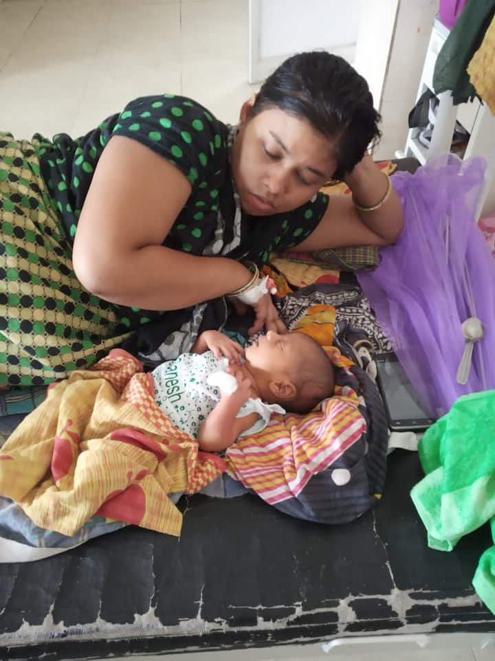A woman looks at her new born child at a hospital Bhadrak, Odisha.
