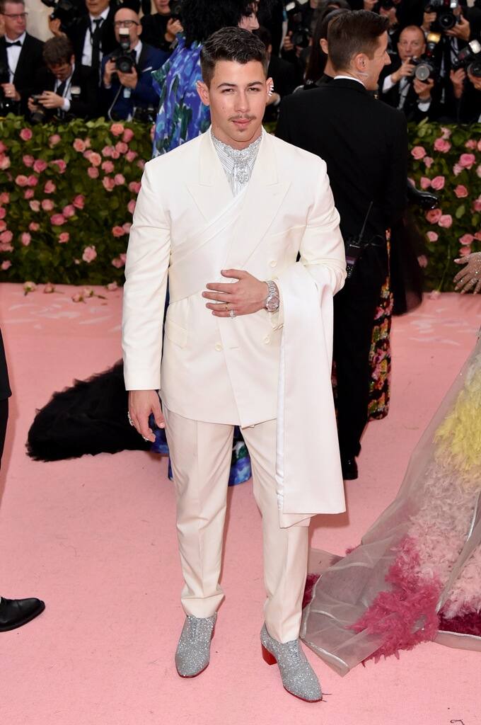 While, Nick looked dapper in a white Dior Men tux and sparkly silver Christian Louboutin shoes