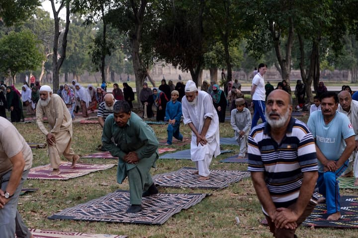 Pakistani people attend a yoga session during the International Yoga Day in Lahore on June 21, 2019. - Indian Prime Minister Narendra Modi led the way for International Yoga Day on June 21, performing sun salutations and other flexible feats in a mass session with an estimated 30,000 other devotees of the discipline. (Photo by ARIF ALI / AFP)