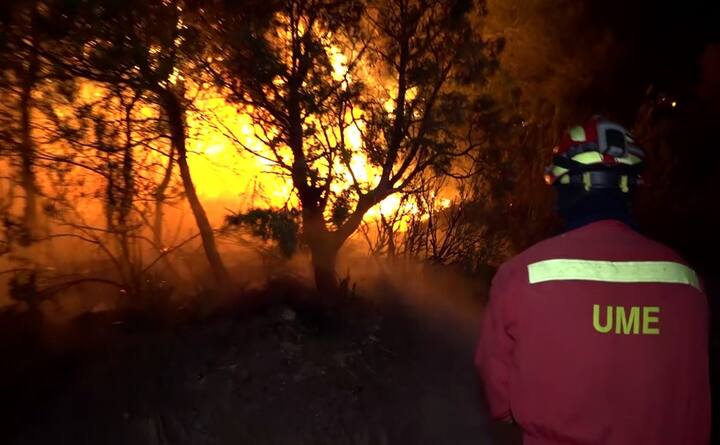 The heatwave that has engulfed Western Europe kindled the year's first serious wildfire in the mountainous region of Tarragona district of Spain, endangering a nuclear power station and forcing people to evacuate the area. / An image grab taken from a video released on June 27, 2019 by the Spanish Emergency Military Unit (UME) shows a fireman trying to extinguish a wildfire near Torre de l´Espanyol in Ribera d´Ebro, on the banks of the river Ebre, northeastern Spain. (Photo by Handout / UME / AFP) 