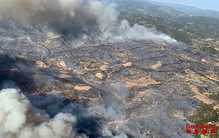 Flames have consumed 4,000 hectares (10,000 acres) of forest. According to fire-fighters, the area of land affected by the fire might reach 20,000 if they are not able to douse the flames soon.This handout aerial picture released on June 26, 2019 by the firefighters of Catalonia, Bombers Generalitat Catalunya, shows a wildfire at Torre de l´Espanyol in Ribera d´Ebro, on the banks of the river Ebre, northeastern Spain. - Authorities raised alerts as Europe's record-breaking June heatwave threatened to intensify with temperatures heading into the 40s Celsius. The choking heat has prompted traffic restrictions, sparked forest fires and fanned debate over public nudity as sweltering Germans stripped off. (Photo by Handout / Bombers Generalitat Catalunya / AFP) 