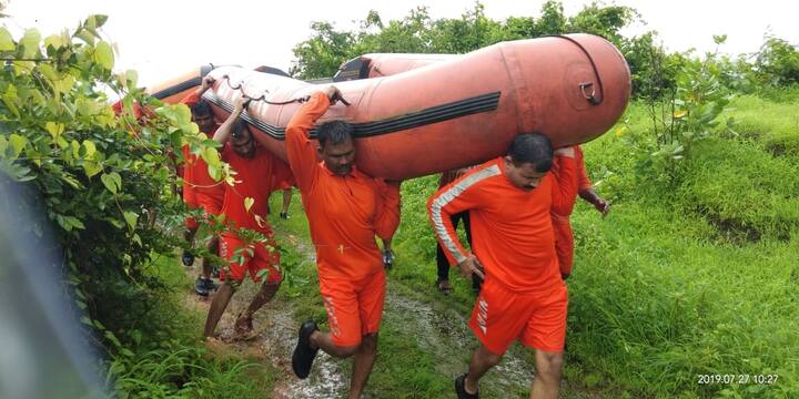 NDRF employees carrying boats in order to rescue the stranded passengers 