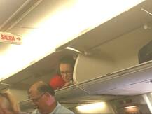 BIZARRE! Flight Attendant Crawls Into Overhead Bin, Passengers Perplexed