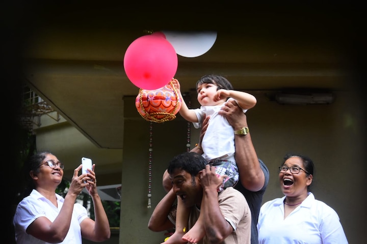 Taimur looked elated as he sat on someone's shoulders while he triee to reach the handi.