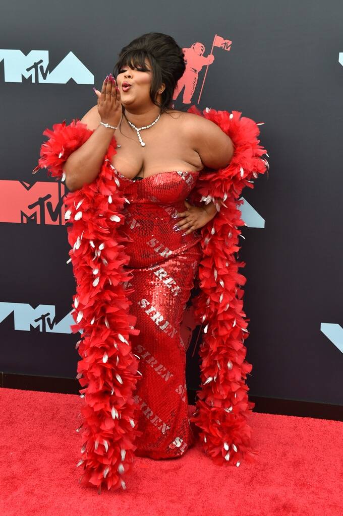 Singer Lizzo had heads turning in a bold red 'Siren' dress complete with feather boa [pic credit: Gettyimages] 